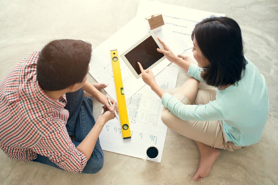 personas que buscan planos de oficinas de construcción y evaluar espacios